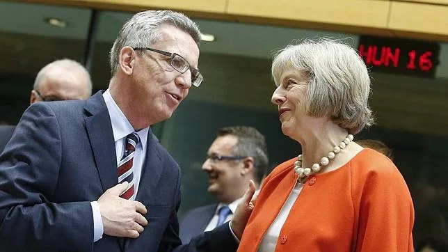 El ministro del Interior alemán Thomas de Maziere (i) conversa con su homóloga británica Theresa May (d)
