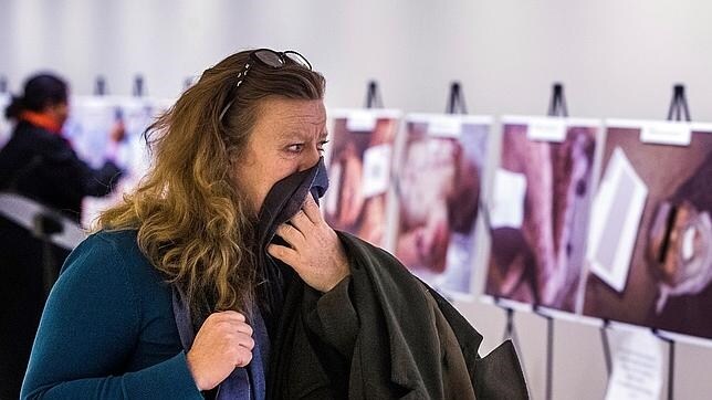 Una mujer se tapa el rostro tras ver las terribles fotografías de César, en una exposición de la ONU en Nueva York