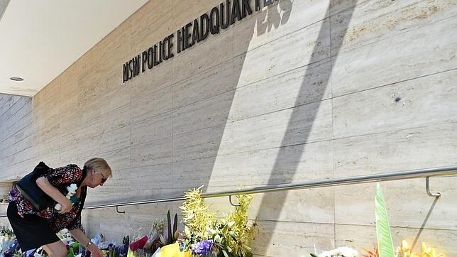 Una mujer ubica un ramo de flores en el lugar donde murió el empleado policial Curtis Cheng