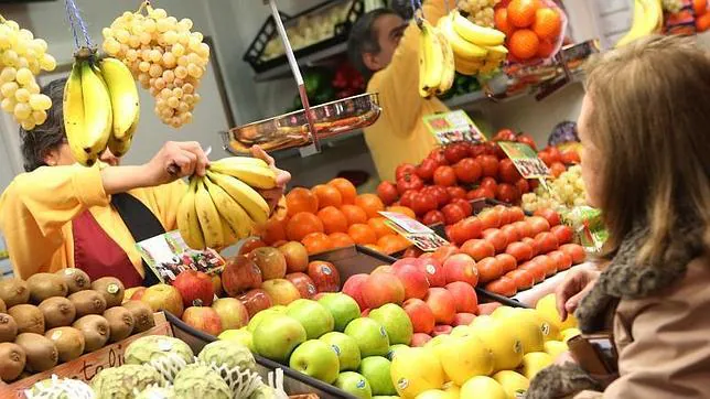 Una clienta adquiere unos plátanos en una frutería del recién estrenado Mercado de Barceló