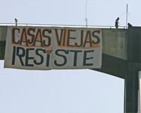Dos ocupas se cuelgan del Puente del V Centenario para que retiren los cargos a los desalojados