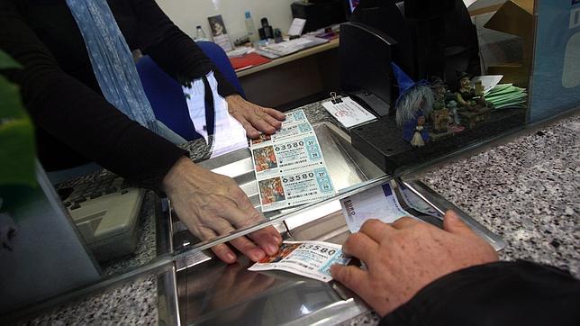 Un comprador adquiriendo en una administración décimos de la Lotería de Navidad