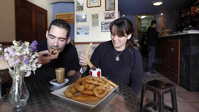 Dos clientes desayunando churros y jeringos en Mari Paz