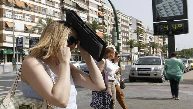 Una mujer se protege del sol mientras pasea por Córdoba