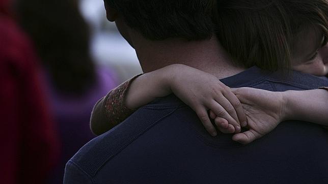 Una niña abraza a su padre durante una manifestación por la custodia compartida