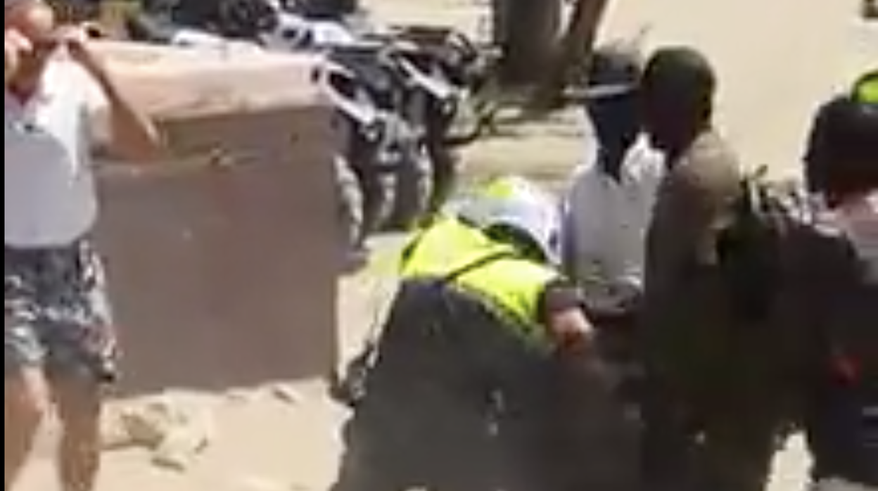 Momento en el que un policía local trata de recuperar la mercancía confiscada