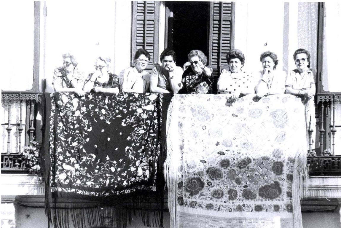 Vecinas de Triana se asoman al balcón al paso de la hermandad en 1987