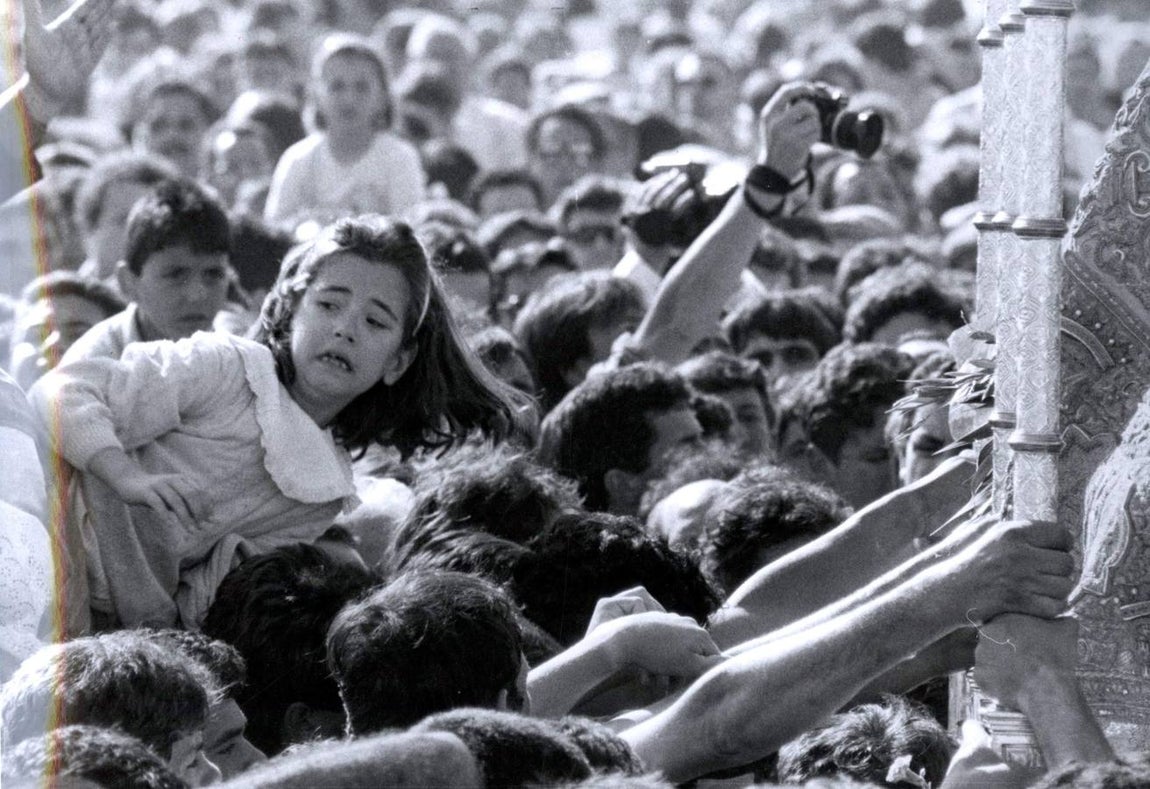 Una niña es acercada hasta la Virgen del Rocío durante la procesión en 1989
