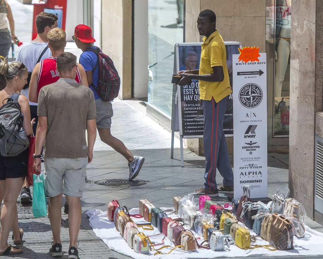 En imágenes, la calle Tetuán de Sevilla invadida por los manteros