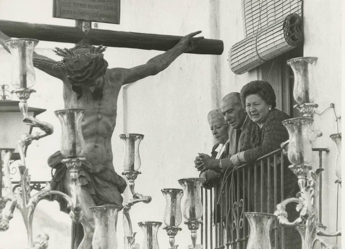 Varias personas observan el paso del Santísimo Cristo de la Salud