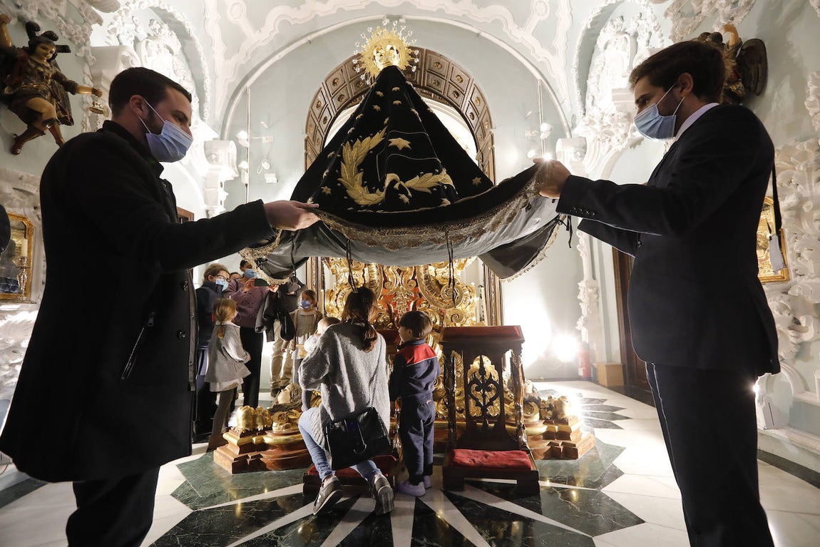 Los niños pasan bajo el manto de la Virgen de los Dolores de Córdoba, en imágenes