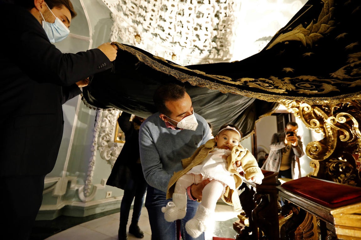 Los niños pasan bajo el manto de la Virgen de los Dolores de Córdoba, en imágenes