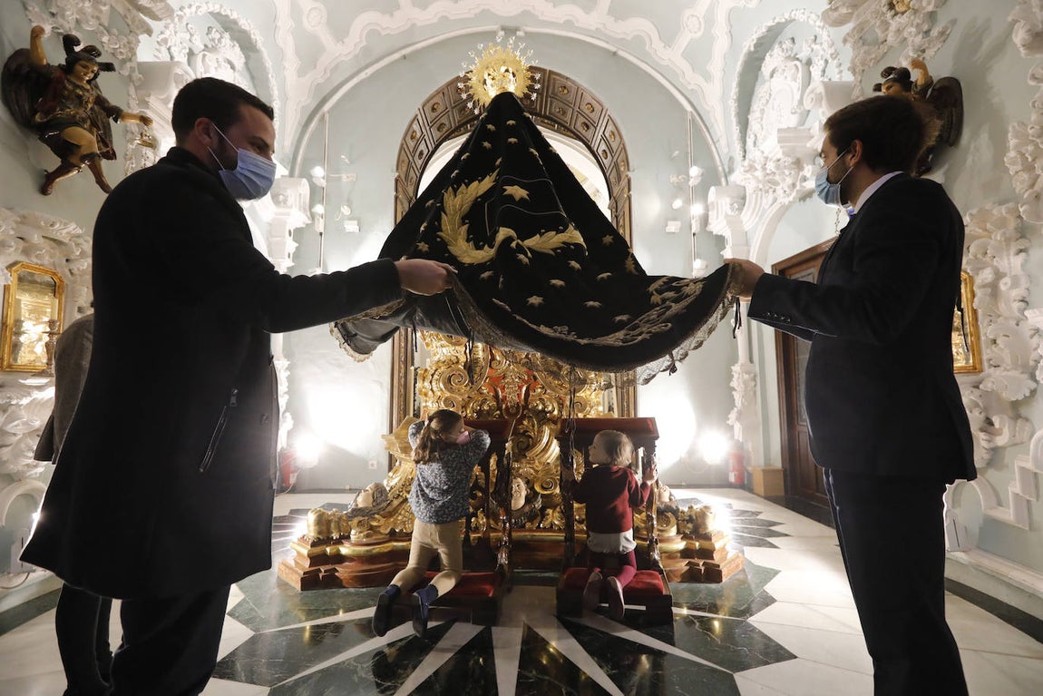 Los niños pasan bajo el manto de la Virgen de los Dolores de Córdoba, en imágenes