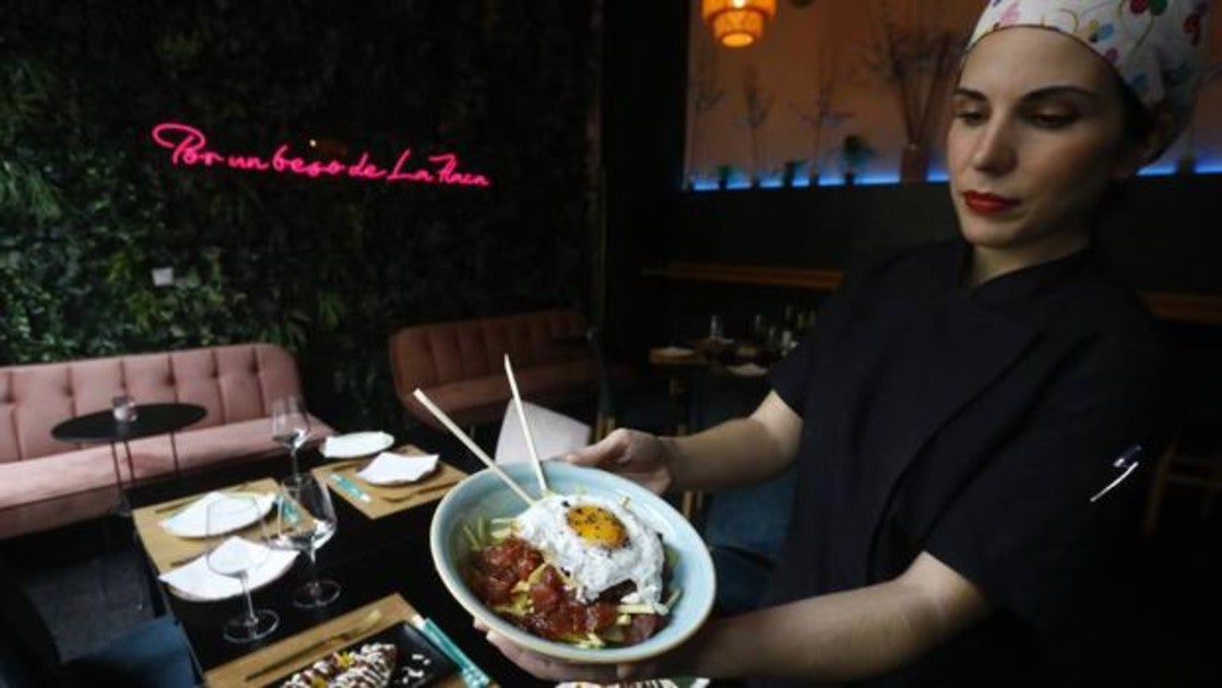 Una trabajadora de Kaótico muestra uno de sus platos antes de servirlo