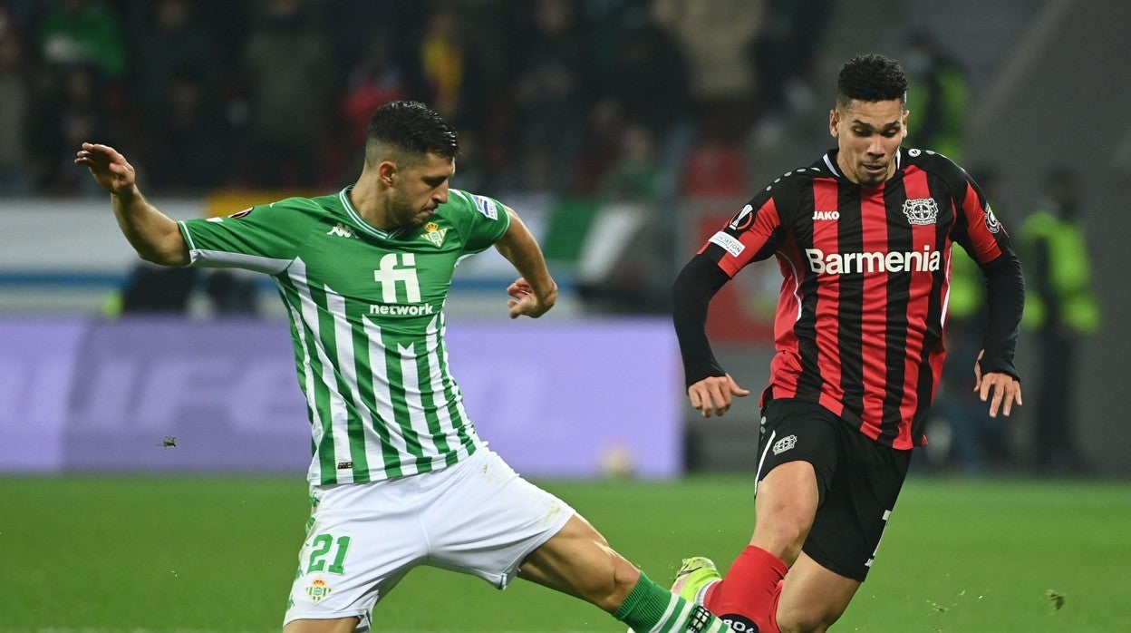 Guido Rodríguez corta el balón ante Paulinho durante el Bayer Leverkusen - Betis