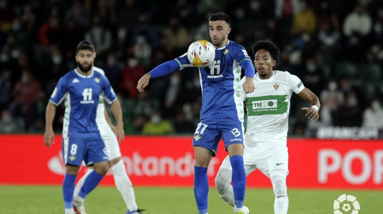 Rober controla con el pecho un balón ante Mojica durante el Elche - BetisLaLiga