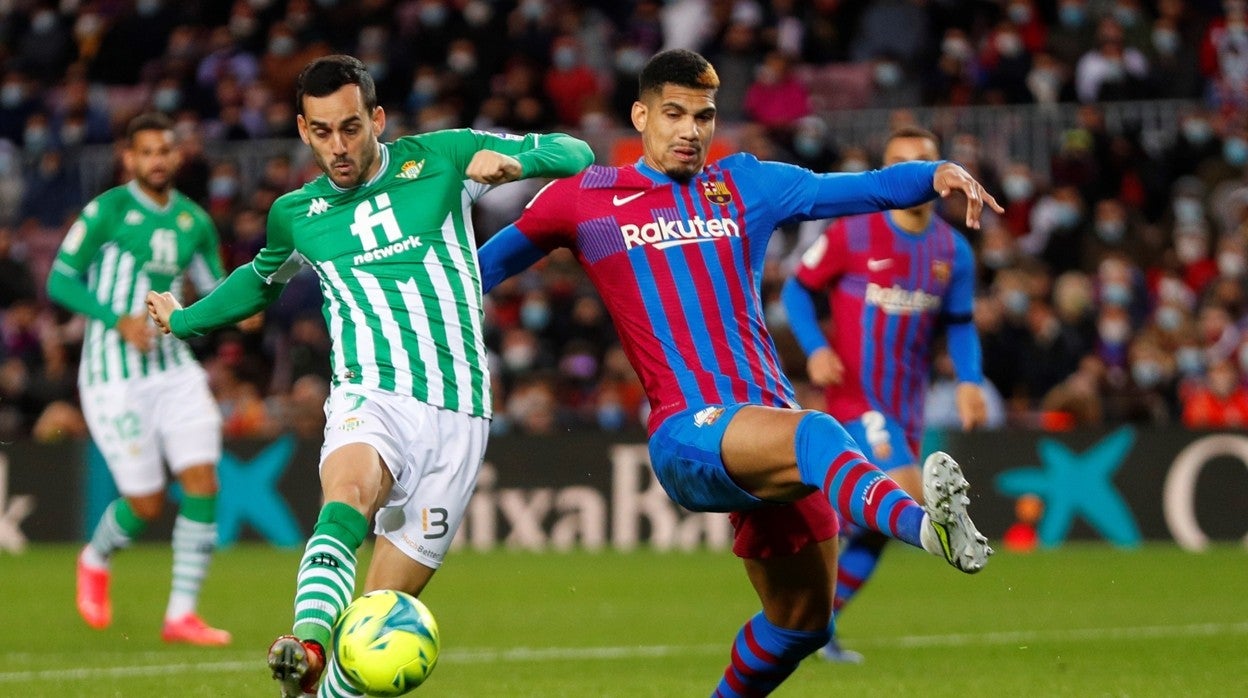 Juanmi lanza un disparo ante Araujo, en un lance del Barcelona - Betis