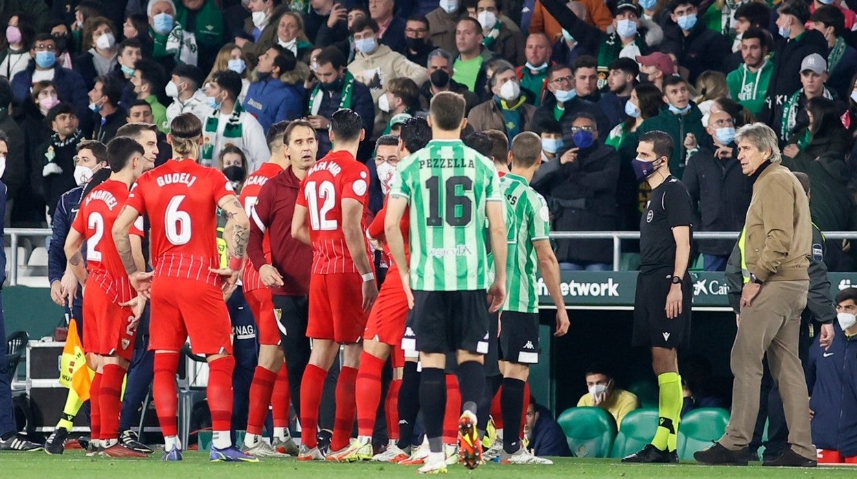 Momento en el que en la zona de banquillos dialogan los jugadores de Sevilla y Betis tras impactar el tubo en la cabeza de Joan Jordán