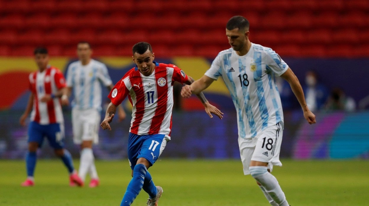 Guido Rodríguez conduce el balón ante Alejandro Romero en el Argentina-Paraguay de la Copa América 2021