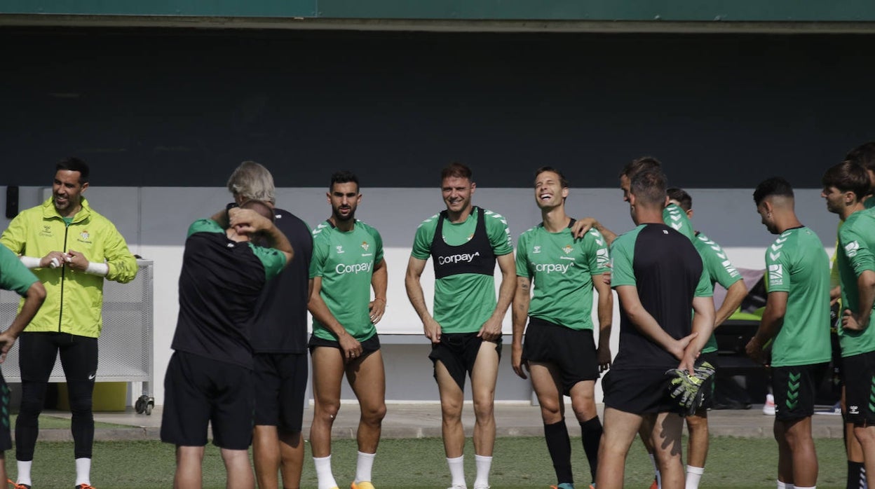 Joaquín y Canales sonríen, entre otros compañeros, durante la charla de Pellegrini en el entrenamiento del Betis