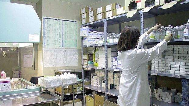 Una enfermera coloca botes de medicinas en una estantería