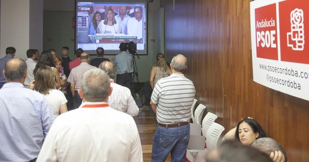Militantes socialistas siguen en la pantalla de su sede en Córdoba las palabras de Susana Díaz