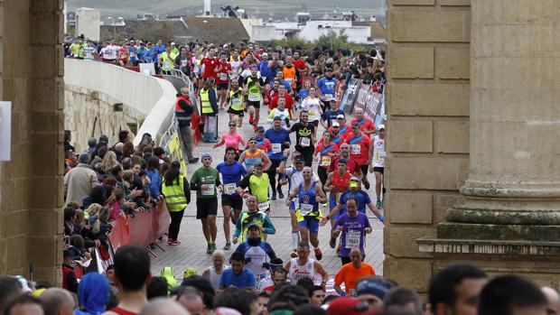 Los participantes a su paso por la Puerta del Puente