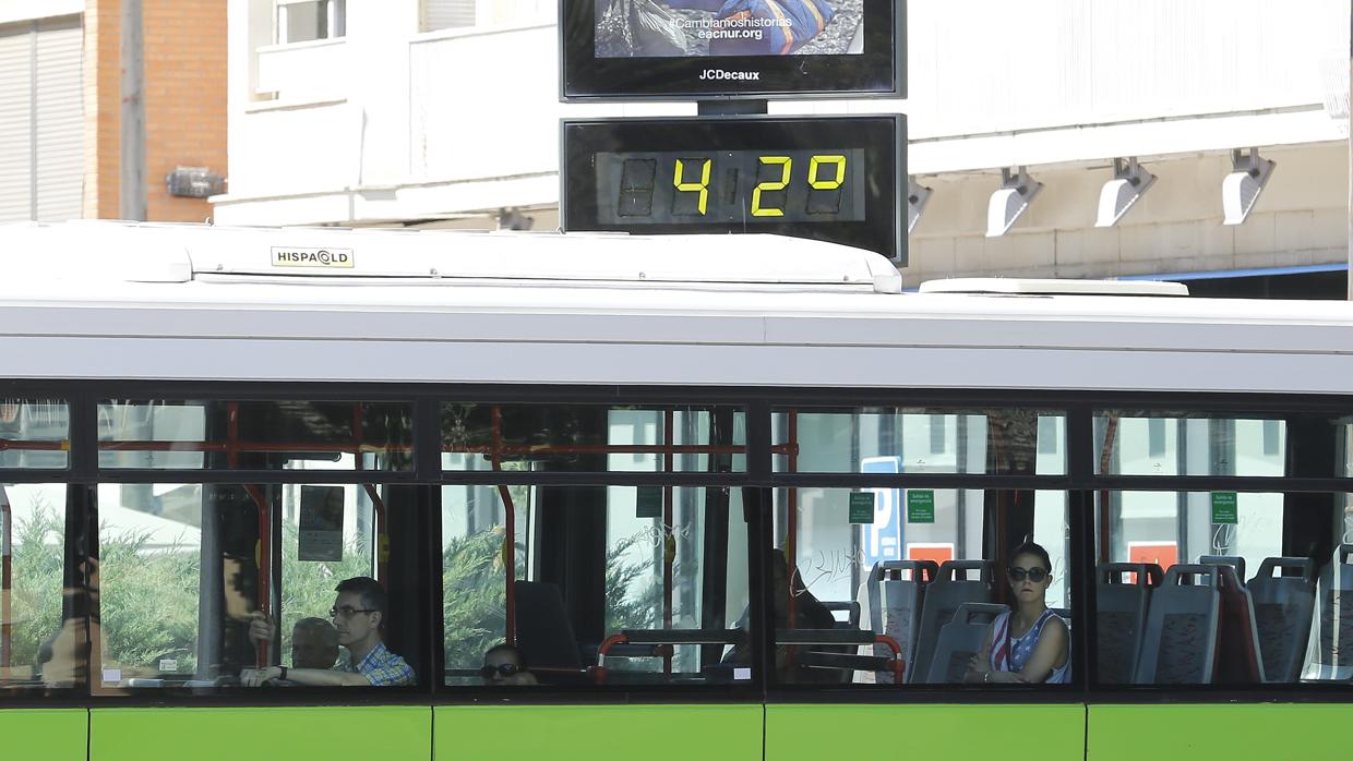 Un autobús de Aucorsa pasa frente a un termómetro en Córdoba