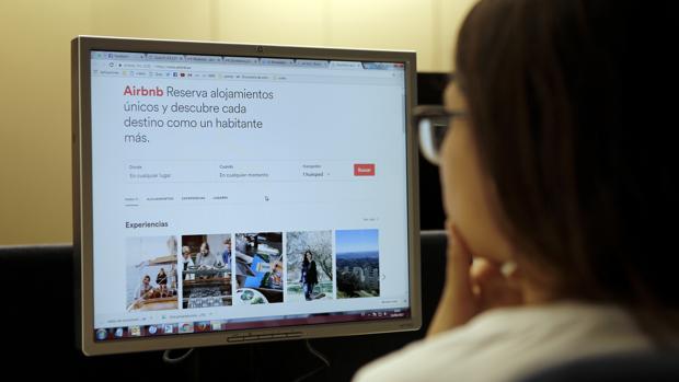 Una joven consulta una página de apartamentos turísticos