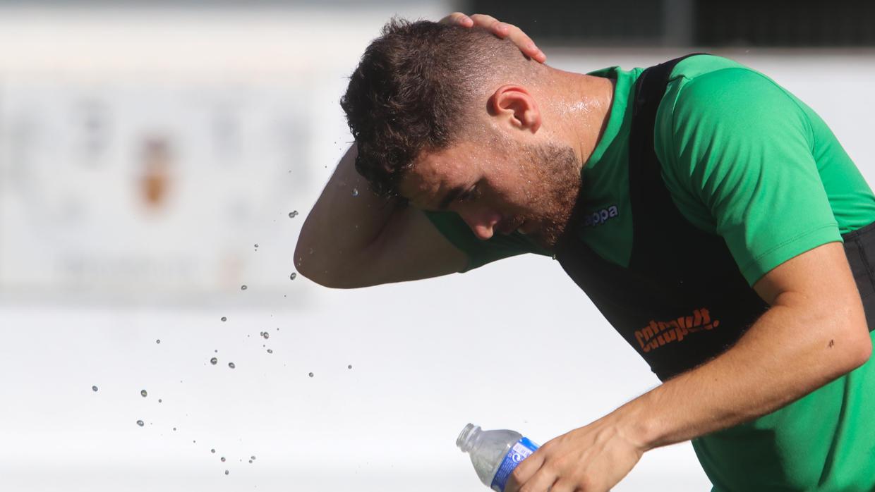 Javi Galán, extremo del Córdoba CF, se moja la cabeza con agua en un entrenamiento