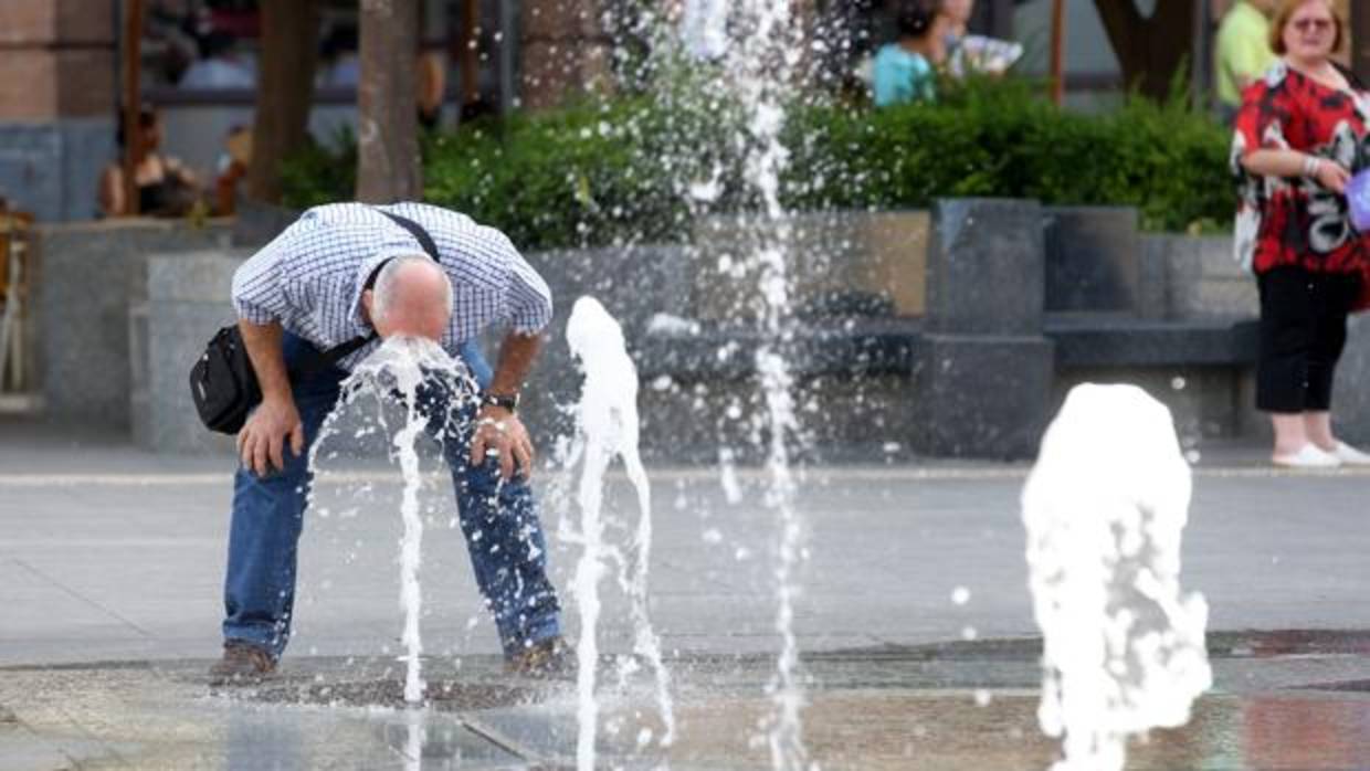 Un hombre se refresca en las fuentes de Las Tendillas
