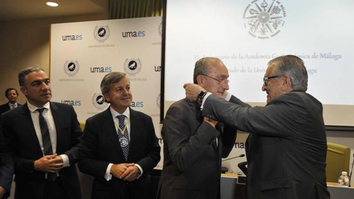 Antonio García del Valle impone al alcalde la medalla de honor junto al presidente de la Academia