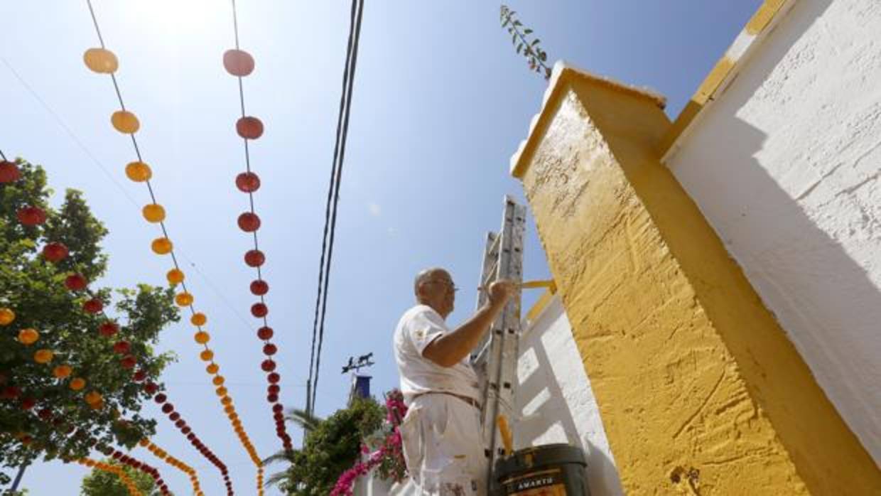 Un hombre da retoques a una caseta antes de la fiesta