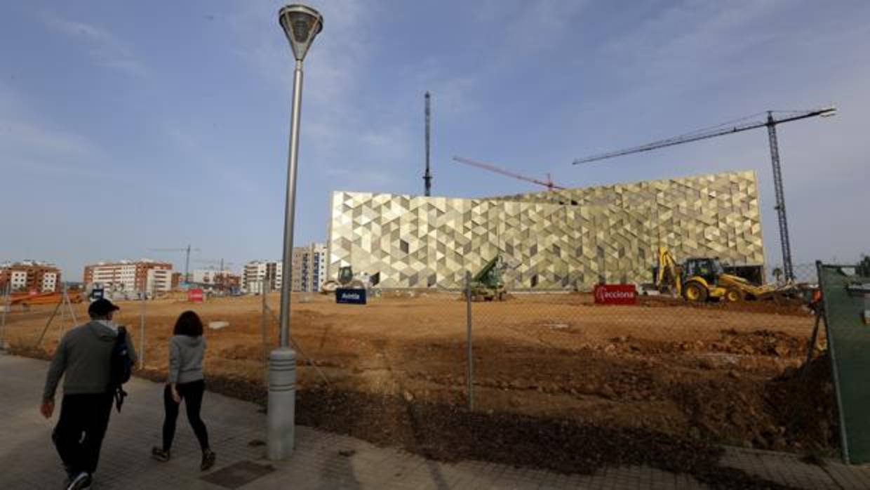 Dos personas pasan por delante del Hospital Quirón en obras