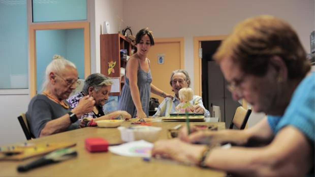 Una monitora junto a unas personas de edad avanzada