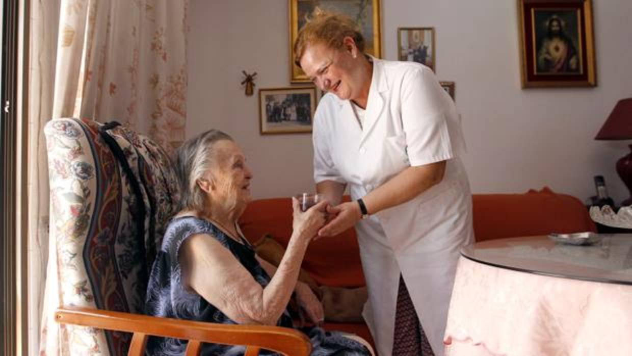 Una mujer de la ayuda a domiciñio en un hogar de Córdoba