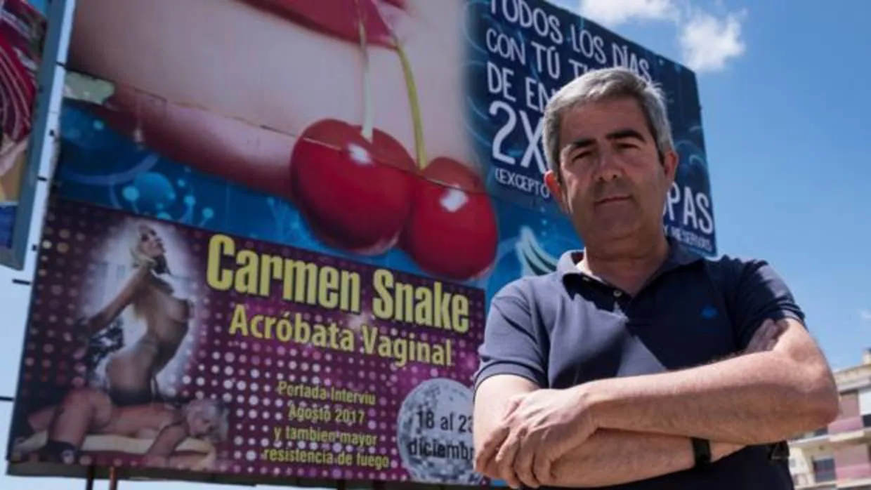 El portavoz de Izquierda Unida en el Ayuntamiento de Lepe (Huelva), Carmelo Cumbreras, posa delante del cartel de la polémica