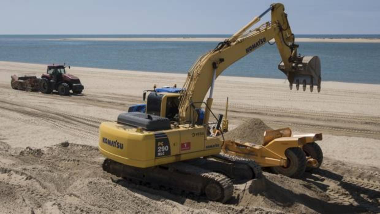 Excavadoras trabajan en la playa del Nuevo Portil, en Cartaya (Huelva), este lunes