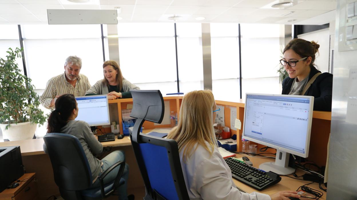Profesionales sanitarios atendiendo usuarios en el centro de salud Los Bermejales, en Sevilla