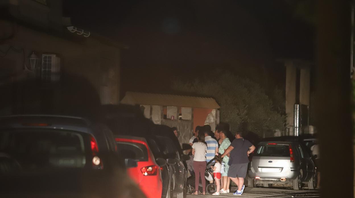 Familiares y vecinos del fallecido en la puerta de la vivienda donde ha ocurrido el siniestro en Córdoba