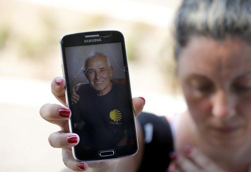 La hija del desaparecido muestra la foto de su padre en el móvil