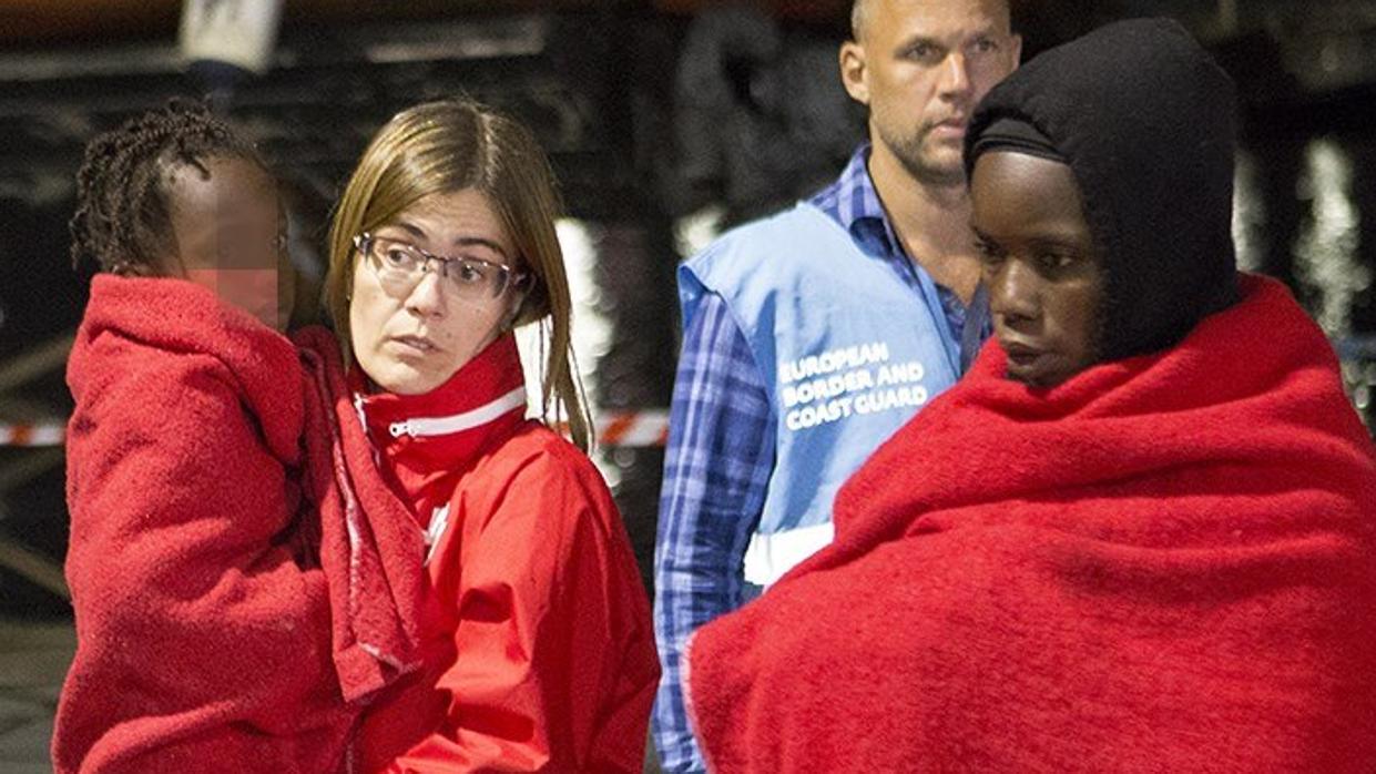 Una trabajadora de la Cruz Roja lleva en sus brazos a un menor recogido este miércoles en el Mar de Alborán