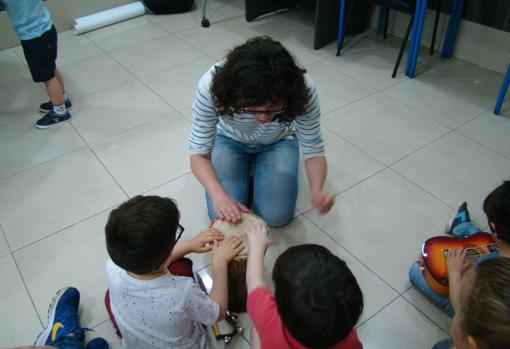 Los niños del taller Música para Ángeles, con un instrumento de percusión