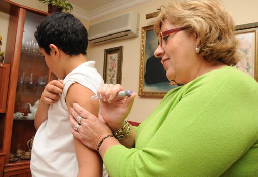 Una mujer le inyecta insulina a un menor