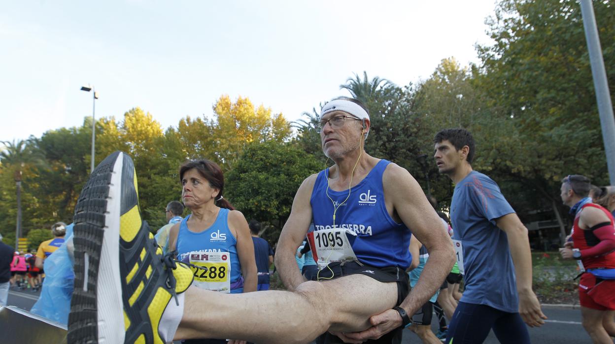 Un corredor estirando antes de la Media Maratón
