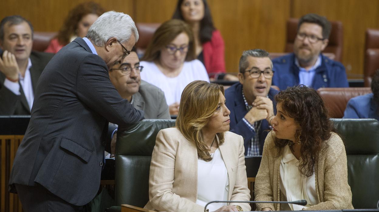 Susana Díaz charla con María Jesús Montero, en un pleno del Parlamento andaluz en 2016