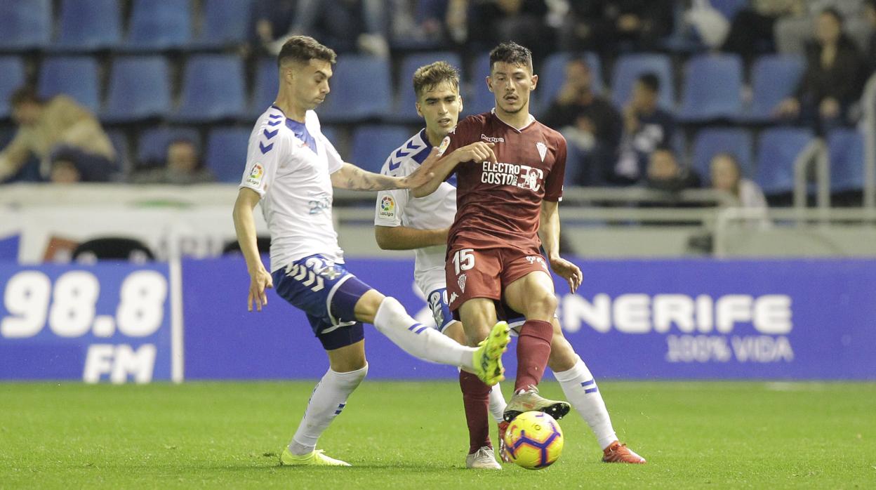 Loureiro toca el balón ante dos rivales en el Tenerife-Córdoba CF