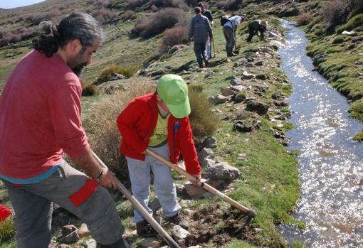 El profesor José María Martín Civantos, a la izquierda, durante una jornada de limpieza de una de las acequias de Lugros.