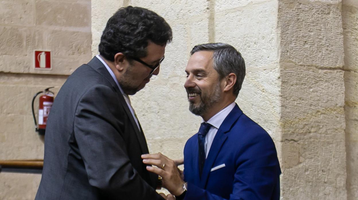 El consejero de Hacienda, Juan Bravo, dialoga con el presidente de Vox, Francisco Serrano en el pleno de este jueves