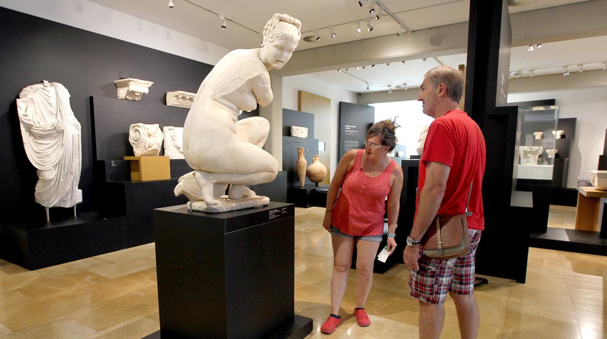 Dos visitantes observan una escultura en el Museo Arqueológico de Córdoba